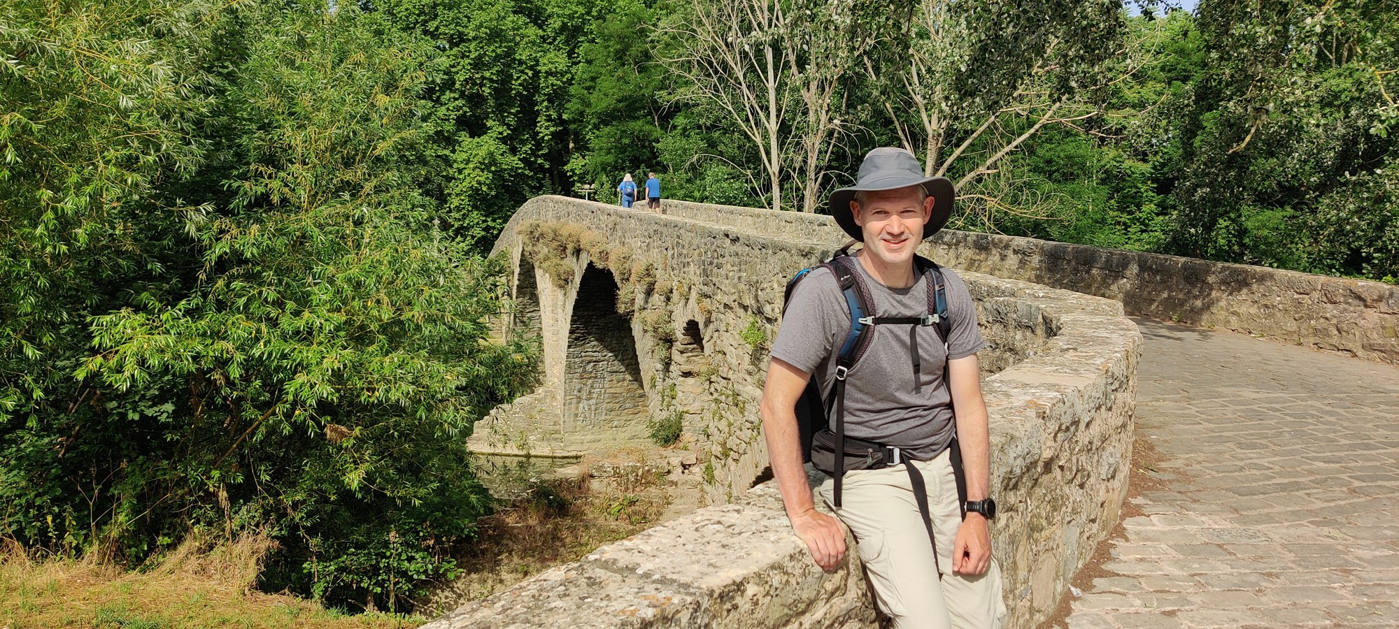 Craig standing on a stone bridge along the Camino de Santiago